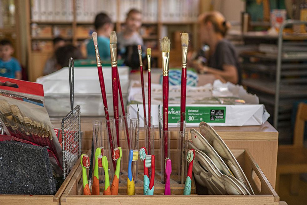 Bild: Ein Werkraum mit Fokus auf Pinseln und Zahnbürsten, die für Farben verwendet werden.